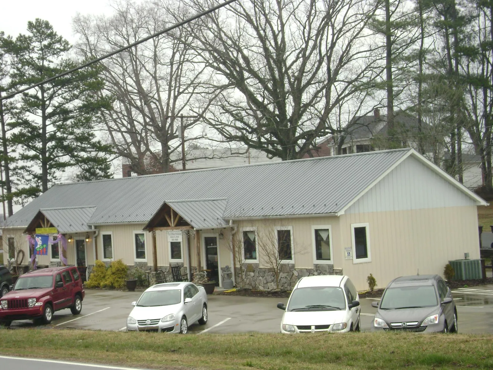 Gray metal roof with timber entry brackets on a small commercial building in Cecil